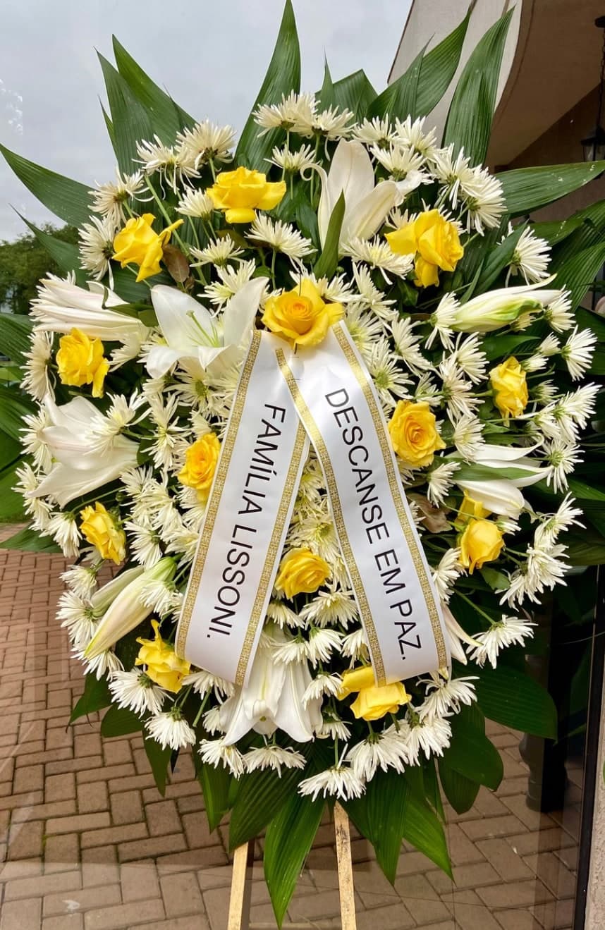Coroa nº 05: flores brancas e amarelas com lírios e faixa de homenagem