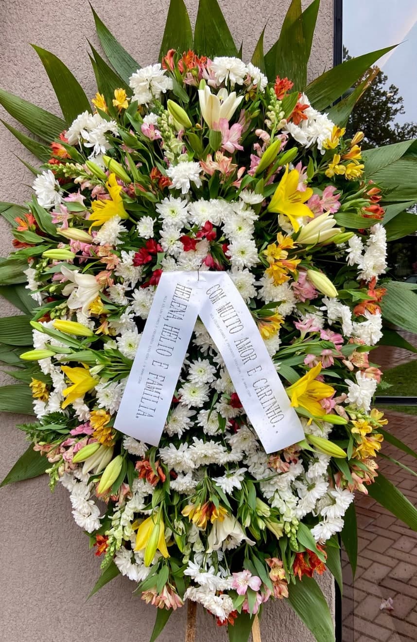 Coroa nº 14: flores brancas, amarelas e laranja com lírios e faixa de homenagem