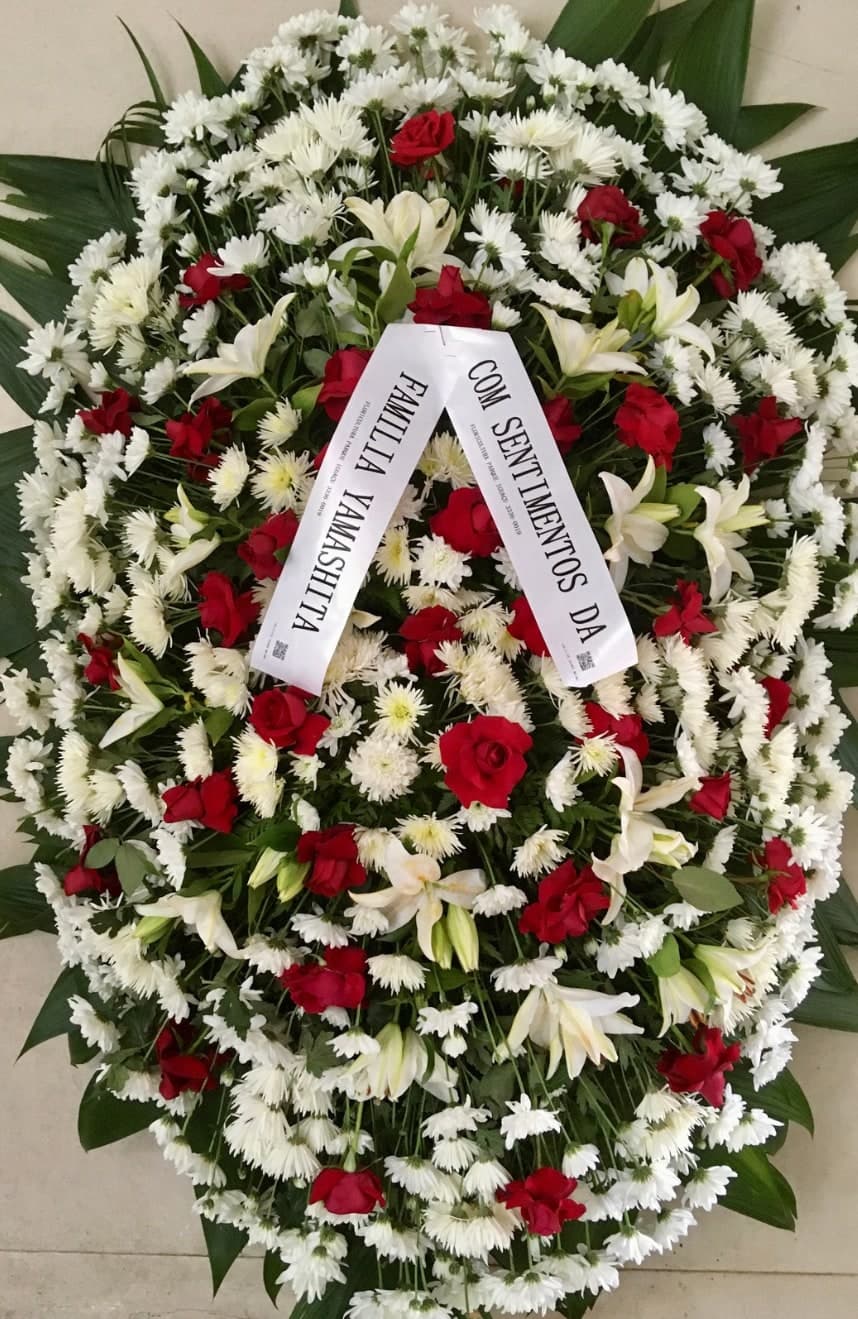 Coroa nº 15: flores brancas com rosas vermelhas e faixa de homenagem